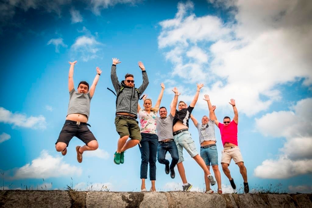 Corporate team jumping together outdoors