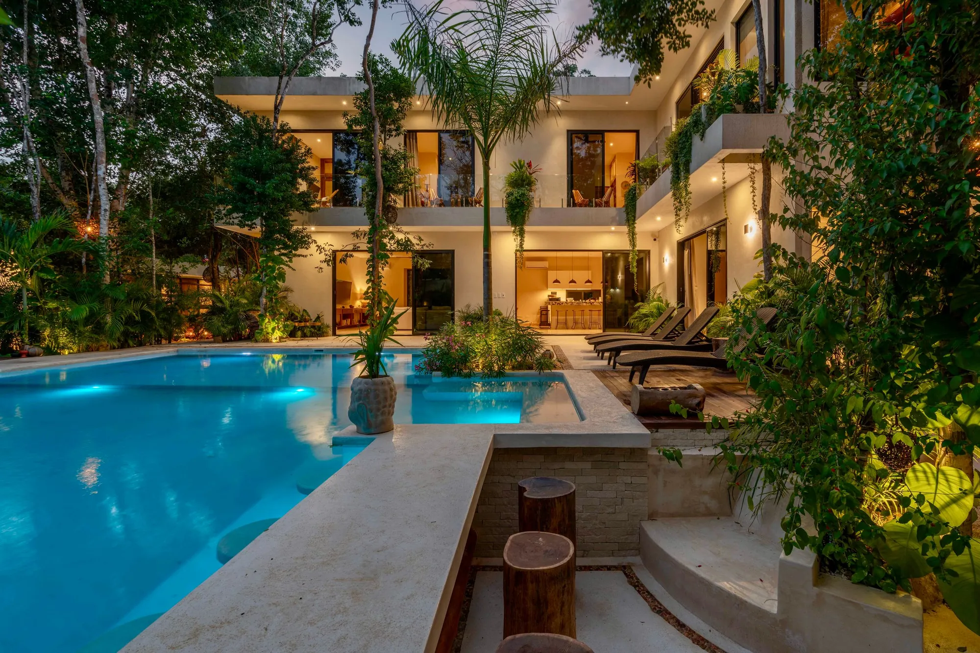 Private tropical villa with an illuminated pool at dusk in the Riviera Maya