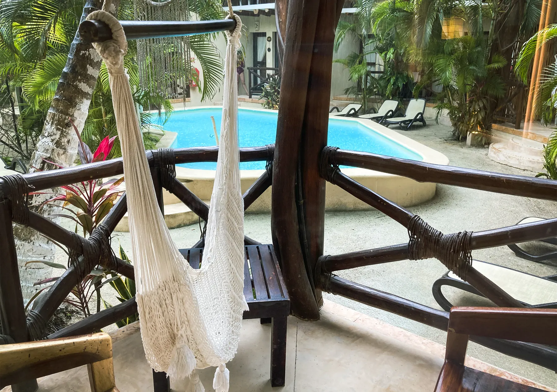 A hammock on a balcony above the hotel pool