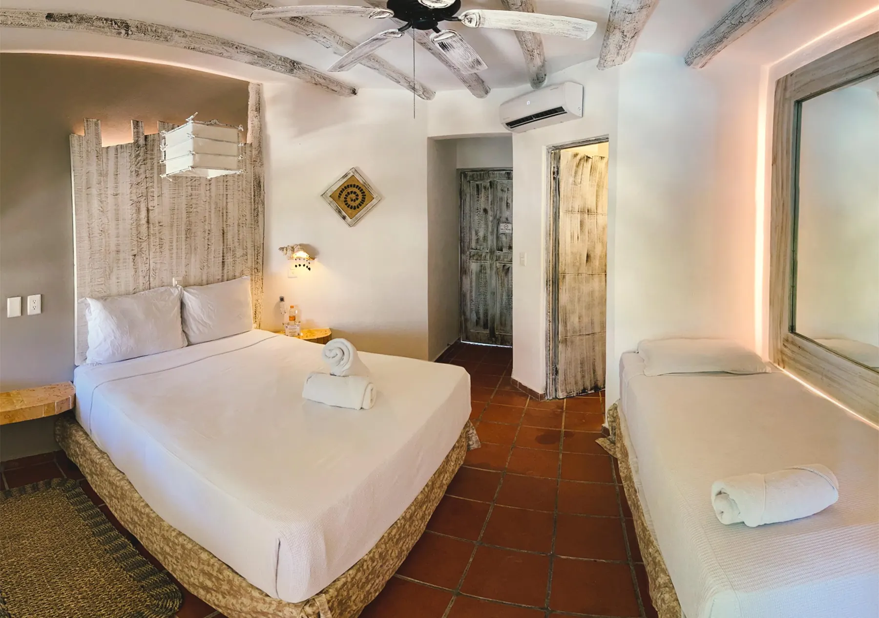 A bright beach hotel room with a queen bed