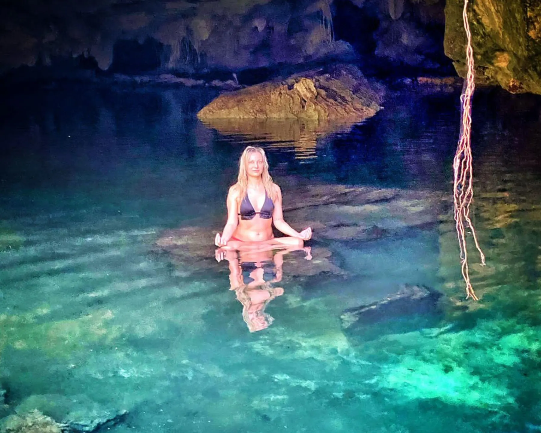A guest meditating in a cenote