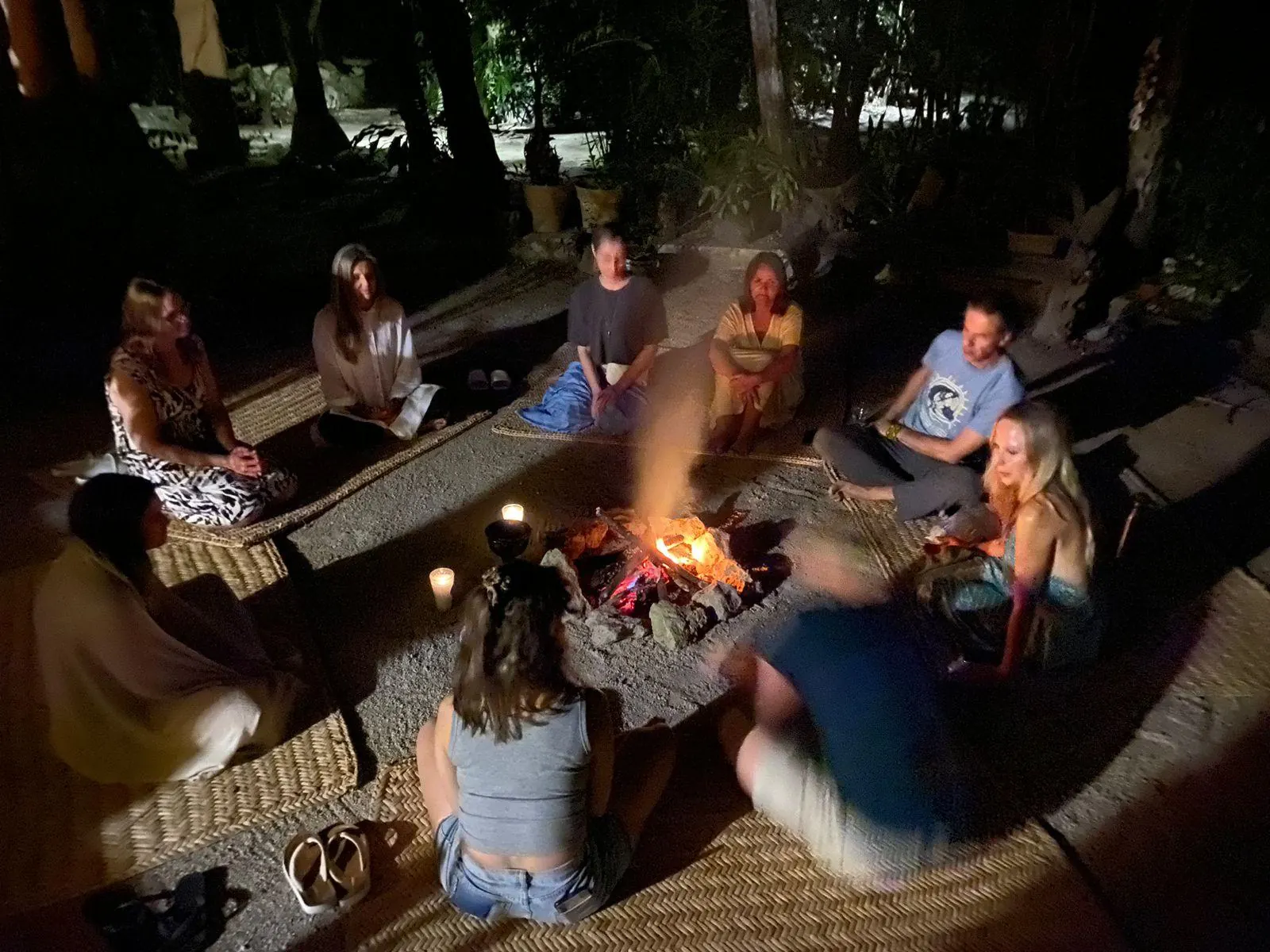 Guests around an evening fire in the jungle