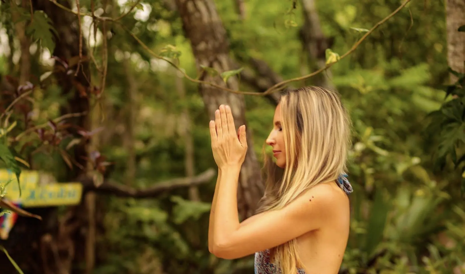 Gabriella with hands at her heart in the jungle