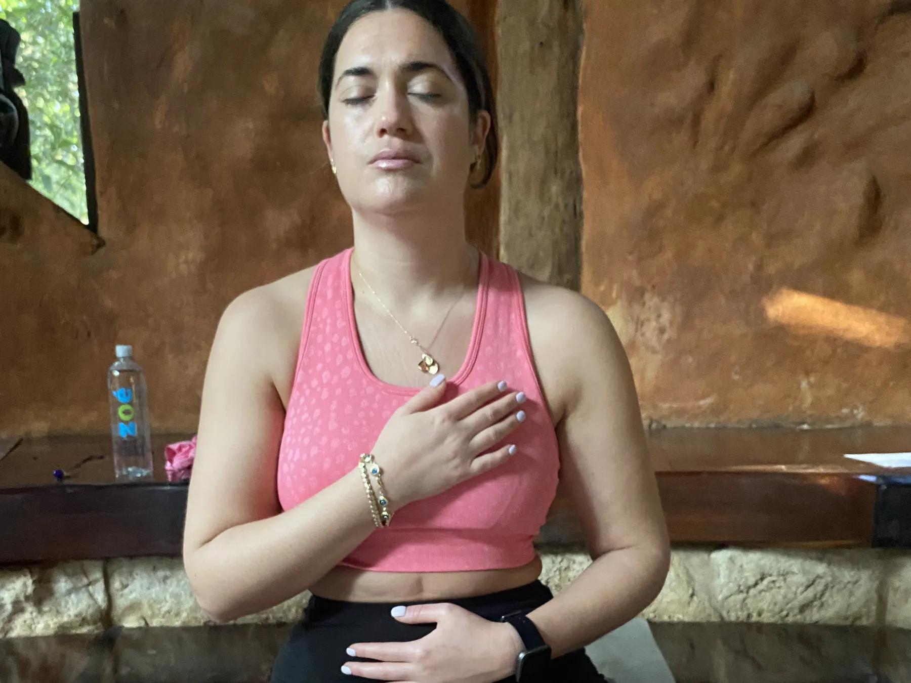 A guest in a quiet moment of breath on her yoga mat in the jungle lodge